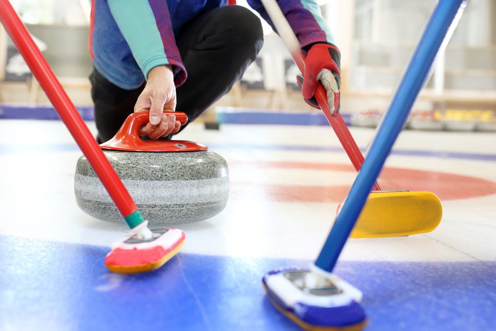 Curling,,Team,Playing,On,The,Ice. Arbeitsunfall beim Eisstockschießen